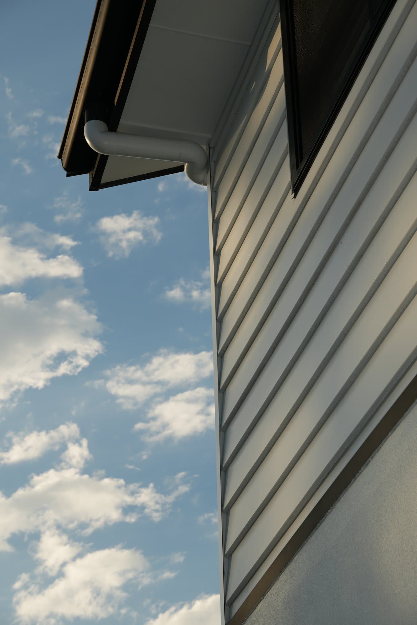 Clean exterior cladding and gutter detail by JTR Built